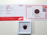 un gros plan sur un diamant rouge dans une boîte posée sur une table
