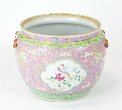 un vase rose orné d'un oiseau, posé sur une table