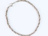 a close up of a silver bracelet on a white background