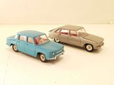 two toy cars sitting next to each other on a white surface