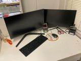 two computer monitors and a keyboard on a desk