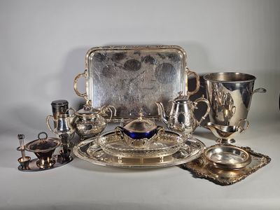une assiette en argent, ainsi que des tasses et des plats en argent, posés sur une table