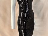 une robe noire à paillettes, à col haut et à manches longues