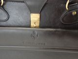 a black leather bag with a gold lock on it