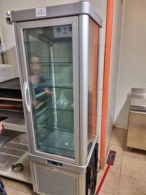 a woman standing in front of a refrigerator in a kitchen