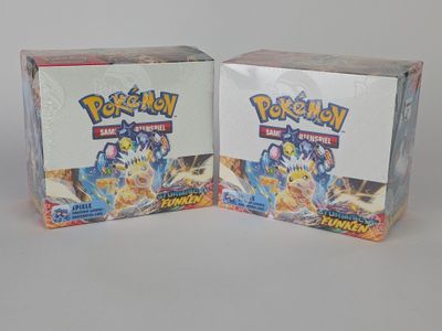 Deux boîtes de cartes à collectionner Pokémon sont posées côte à côte