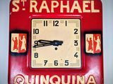 une horloge rouge accrochée au mur d'une pièce