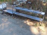un banc en métal posé au milieu d'un chemin de terre