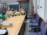 une longue table entourée de chaises bleues au milieu d'une pièce