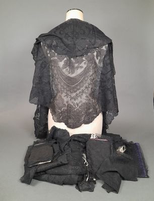une photo d'un mannequin vêtu de vêtements et d'accessoires noirs, posé sur une table