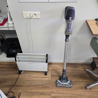 a vacuum that is sitting on the floor next to a desk