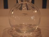 a clear glass vase with a black handle on a table