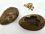 two pieces of bronze are sitting next to each other on a white surface