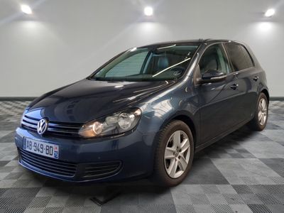 La Volkswagen Golf bleue est garée sur un sol en carrelage à damier.