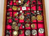 une vitrine en bois remplie d'une multitude de boutons