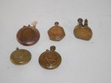 four small brass bells and a small brass bell on a white surface