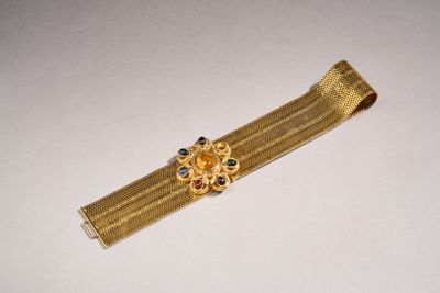 un gros plan d'un bracelet en or orné d'une fleur