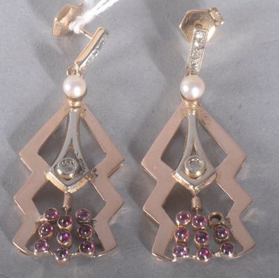 une paire de boucles d'oreilles ornées de perles et de diamants sur un fond en argent