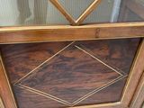 a wooden cabinet with a glass door on top of it