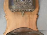 a wooden wall mounted with a metal pan on it