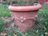 un grand pot contenant une plante, posé sur l'herbe