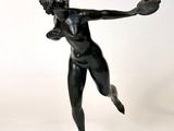 statue d'une femme tenant une raquette de tennis dans la main droite