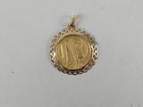 a gold coin pendant with a woman ' s face on it