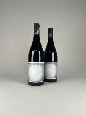 two bottles of wine sitting next to each other on a table