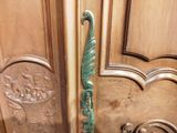 a wooden door with a green handle and a basket of flowers on it