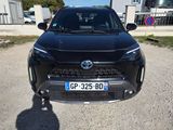 une Toyota RAV noire garée sur un parking en gravier à côté d'un immeuble