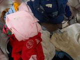 a pile of clothes sitting on top of a bed