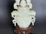 an image of a white jade vase sitting on top of a wooden stand