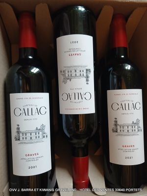 trois bouteilles de vin sont posées sur une table dans un carton