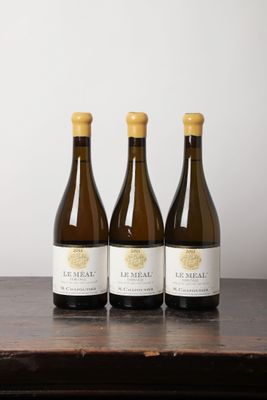 trois bouteilles de vin posées sur une table en bois