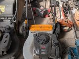 several lawn mowers are lined up on the ground in a garage