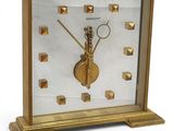a gold clock that is on display on a table