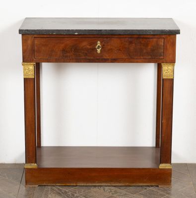 a wooden table with a black marble top and gold accents