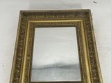gold framed mirror with ornate design on a white background