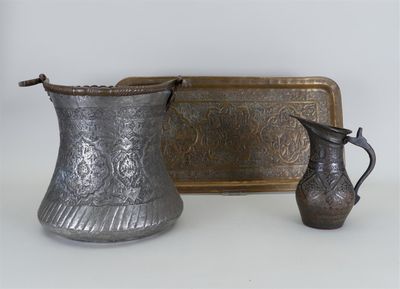 un pichet en argent et un plateau en argent posés sur une table