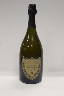 an old bottle of wine sitting on top of a white table