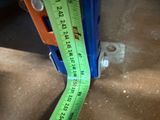 a measuring tape on the floor next to a piece of metal