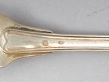 silverware spoon and spoon rest on a white surface