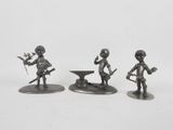 three metal figurines of a boy with a sword and a bowl