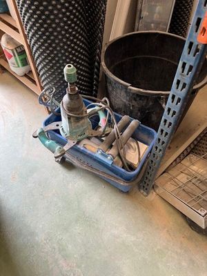 a blue tray with tools and a bottle of wine on the floor
