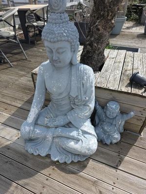 une statue de Bouddha assis sur une terrasse en bois