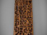 une vieille plaque en bois sur laquelle figurent de nombreux motifs différents