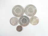 several different coins are arranged in a circle on a white surface