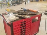 un chariot rouge sur lequel sont posés de nombreux outils