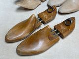 four pairs of wooden shoes are lined up on a table