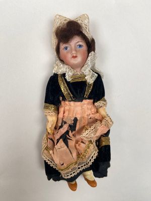 a doll that is wearing a dress and holding a teddy bear
